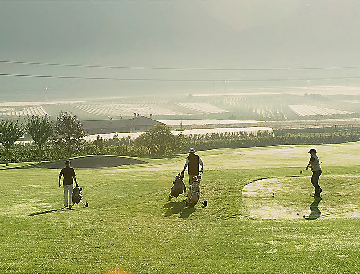 Tre persone sul campo da golf dell'albergo di Golf