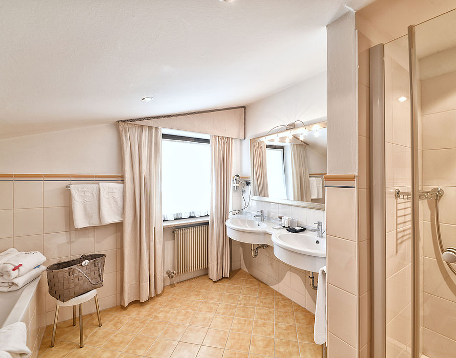 Bathroom with two sinks, shower, bath and long curtains