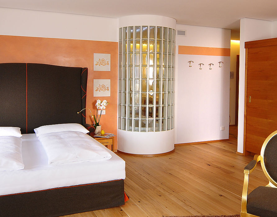 Orange bedroom with black bed and a wardrobe