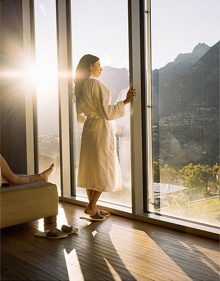 Woman in bathrobe in relaxation room with sunlight