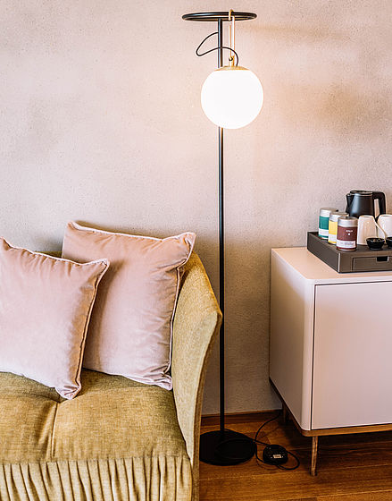 Floor lamp next to beige sofa in Hotel Hohenwart