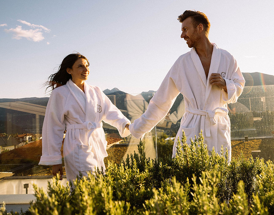 Couple in bathrobe walking on terrace