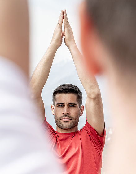 Mann im roten T-Shirt macht Yoga
